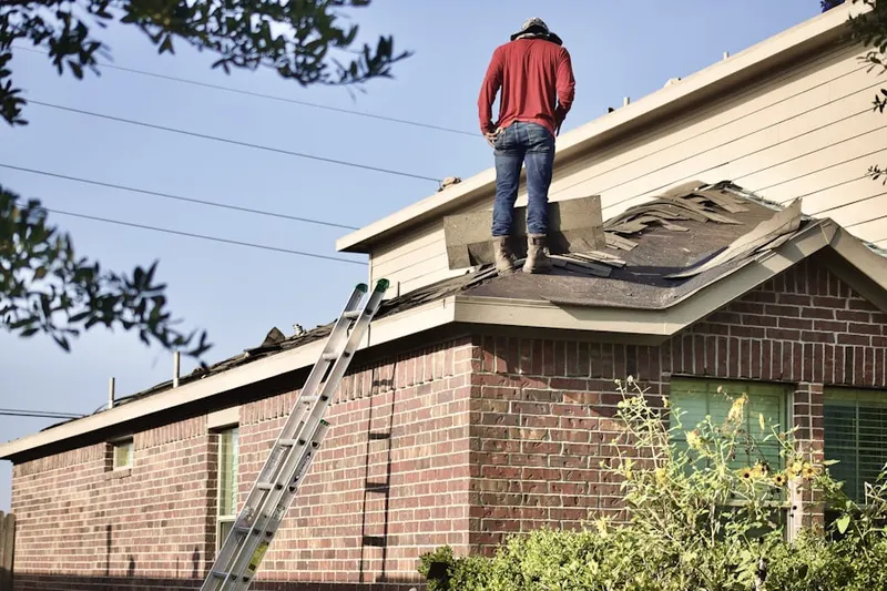 Professional roofer working on a residential roof in Westford Station